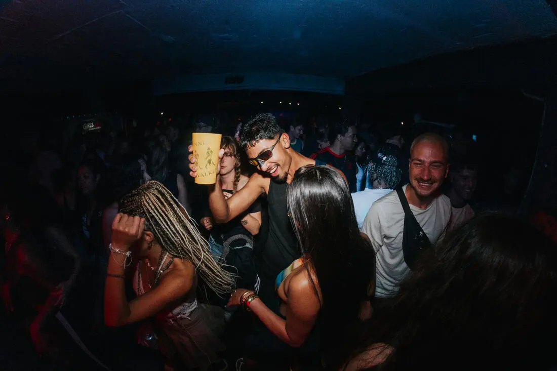 Traveller dancing and smiling at a baile funk party at night
