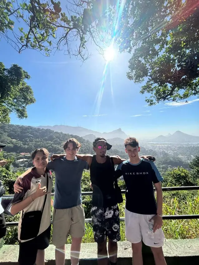 Four friends with their local guide at a mountaintop viewpoint
