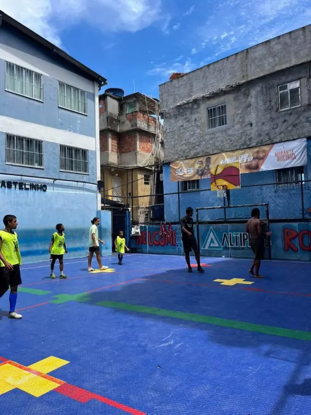 Kids playing basketball on a community sports court in Rocinha